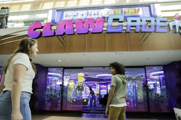 Children outside ClawCADE arcade, featuring vibrant signage and gaming attractions, highlighting family-friendly entertainment and franchise opportunities.
